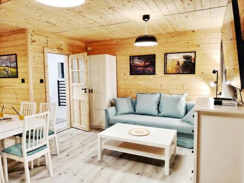 a living room with a blue couch and a table at Pokoje i Domki Na Szlaku in Polanica-Zdrój