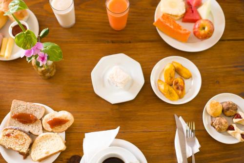 a wooden table with plates of food and drinks at Tropical Beach in Porto Seguro