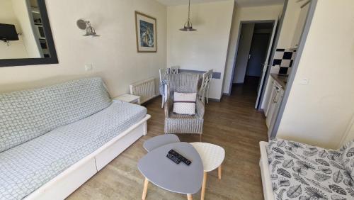 salon z kanapą, stołem i krzesłami w obiekcie CAP COZ plage piscine et jardin w mieście Fouesnant