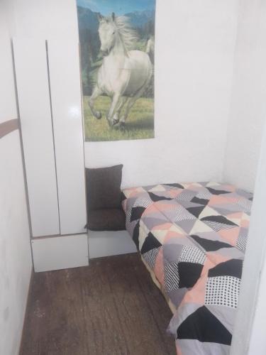 a bedroom with a bed and a picture of a horse at Alojamiento playa mansa 096245748 in Atlántida