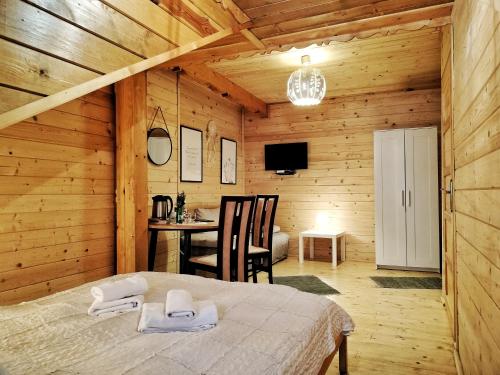 a bedroom with a bed in a wooden room at Pokoje i Domki Na Szlaku in Polanica-Zdrój