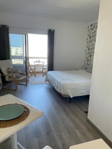 a room with a bed and a table and a room with a window at Ocean View Sunset in Adeje