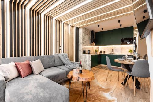 a living room with a couch and a table at Apartamenty Małe Żywczańskie Lux&SPA in Zakopane