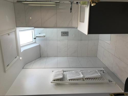 a white bathroom with two white towels on the floor at Pulteney House in Bath