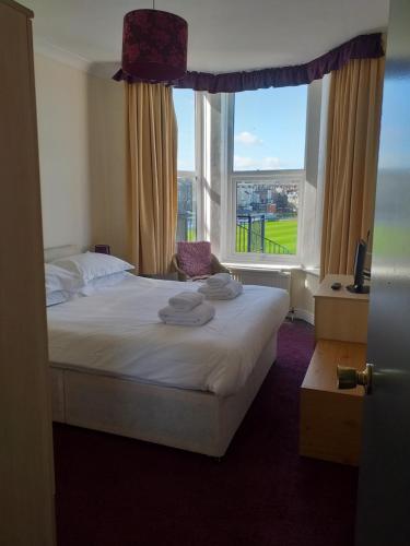 a bedroom with a bed and a large window at Dickie's View in Scarborough