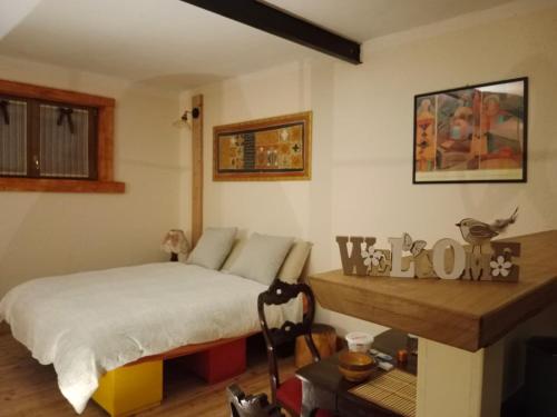 1 dormitorio con cama y mesa de madera en B&B Max & Lory, en Neviano degli Arduini