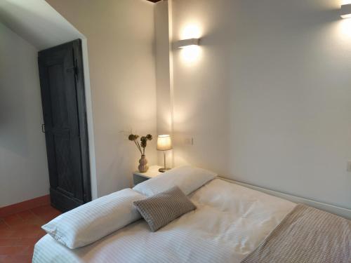 a bedroom with a white bed with two pillows on it at Poggio ai Gelsi in Pienza