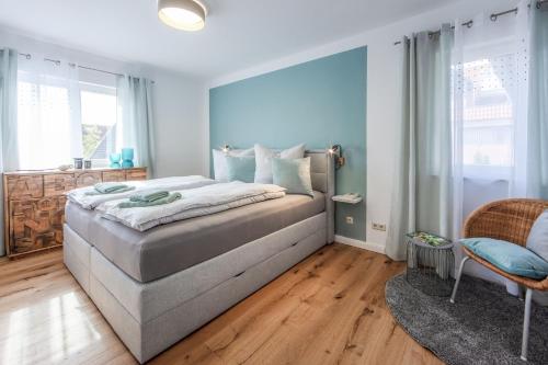 a bedroom with a large bed with blue walls and wooden floors at Seeperle in Gaienhofen