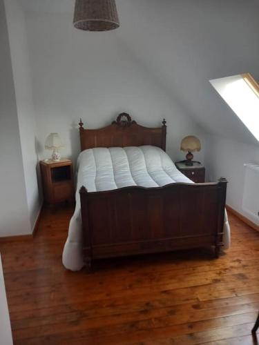 a bedroom with a large bed with a wooden floor at Gite 7pers 3 chambres in Bouvincourt-en-Vermandois