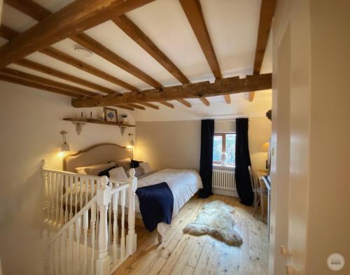 a bedroom with a white bed and wooden floors at Castle View by Peake’s Retreats in Tutbury