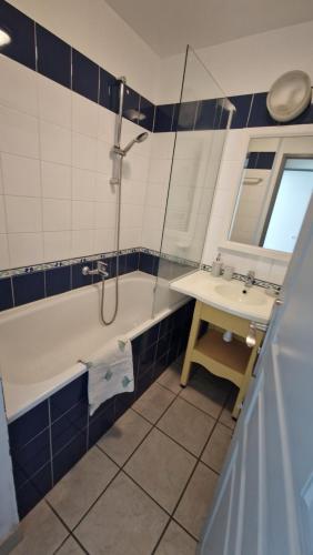 ein Bad mit einer Badewanne, einem Waschbecken und einer Dusche in der Unterkunft Cap coz 5 pers., plage piscine et jardin in Fouesnant