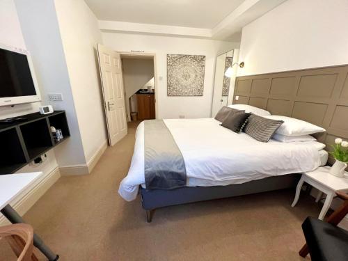 a bedroom with a large white bed and a television at Ferndale Mews in Bristol