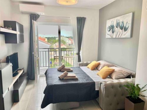- une chambre avec un lit, un canapé et un balcon dans l'établissement Apartment LUKA, à Fažana