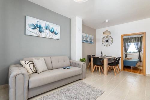 - un salon avec un canapé et une salle à manger dans l'établissement Apartment LUKA, à Fažana