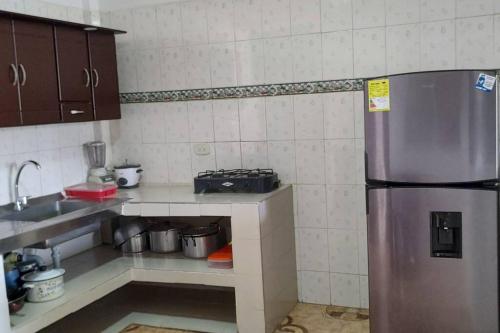 a small kitchen with a stainless steel refrigerator at Hermosa casa familiar in La Tebaida
