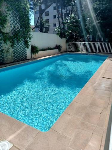 une piscine avec de l'eau bleue dans une cour dans l'établissement Résidence Californie Cannes, à Cannes