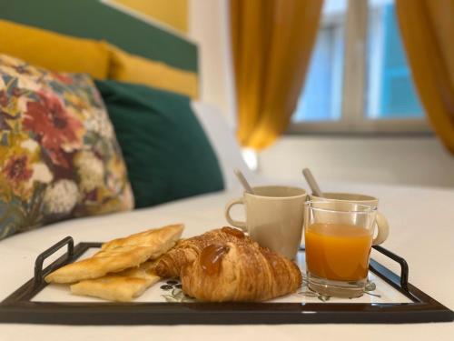 un vassoio con un piatto di pane e succo d'arancia di Happy Family Apartments San Luca a Genova