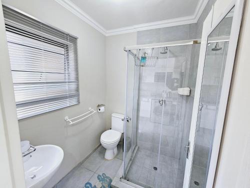 a bathroom with a shower and a toilet and a sink at Quantum Heights - Studio Apartment in Fourways