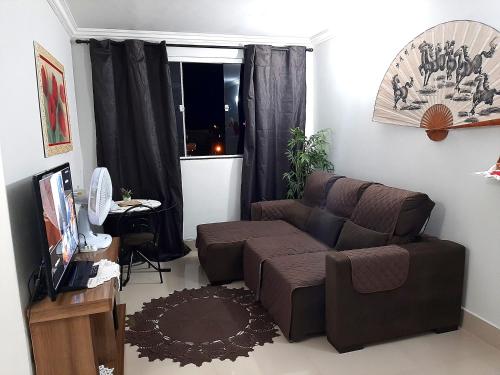 a living room with a couch and a window at Apto aconchegante cuiaba in Cuiabá