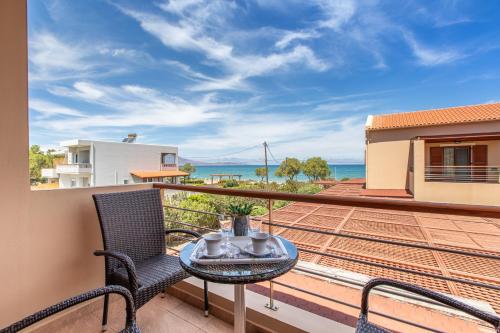 a balcony with a table and chairs and the ocean at Gold Crest Home in Drapanias beach, Nopigia in Kissamos