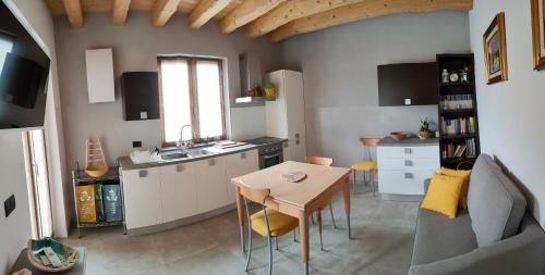eine Küche mit einem Tisch und eine kleine Küche mit einem Waschbecken in der Unterkunft SEMI AL VENTO: la bio-casa nel giardino incantato! in Paesana