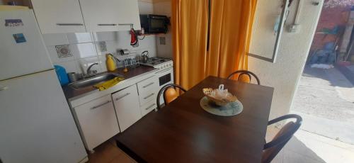 małą kuchnię z drewnianym stołem, stołem i krzesłami w obiekcie DEPARTAMENTO MONOAMBIENTE w mieście San Luis