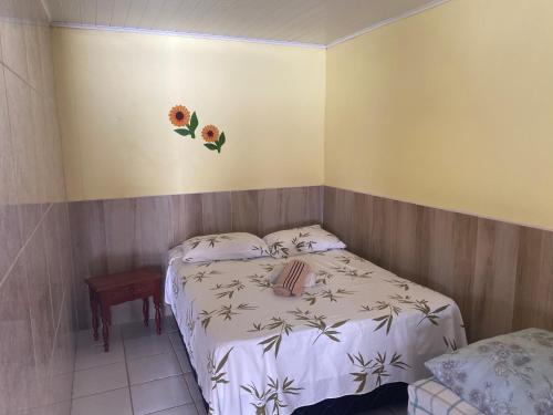 um quarto com duas camas com flores na parede em Pousada Savoya em Ilhéus