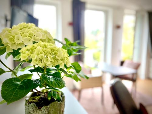 un jarrón con flores amarillas sentado en una mesa en Stadtnah und ruhig, en Gummersbach