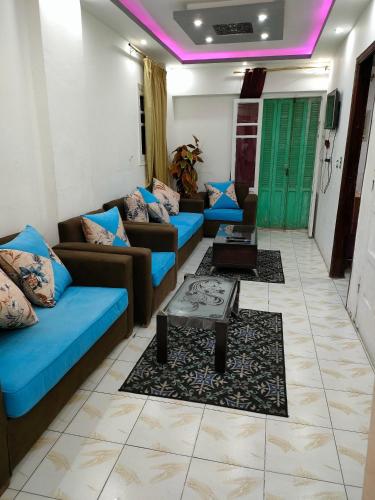 uma sala de estar com sofás azuis e uma mesa em Miami furnished apartment next to Khaled Bin Al Waleed em Alexandria