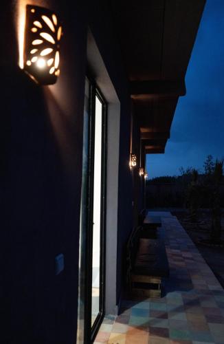a house with a window and lights on the wall at Aghmat Lodge Guest house in Marrakech