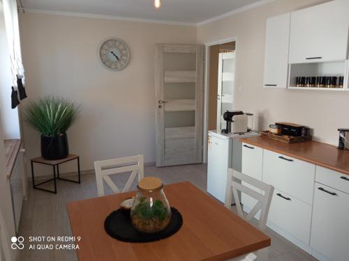 une cuisine avec une table et une horloge murale dans l'établissement Apartament Storczyk, à Augustów