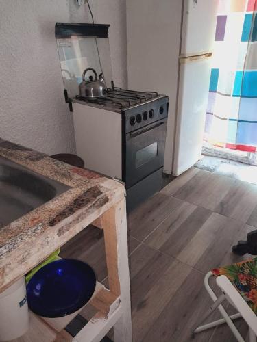 uma cozinha com um fogão e um lavatório em Alojamiento playa mansa em Atlántida