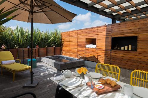 a patio with a table and chairs and an umbrella at Dos Casas Hotel & Spa in San Miguel de Allende