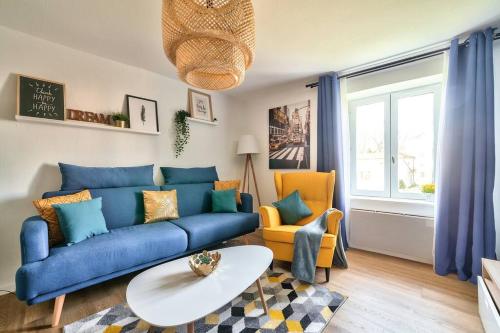 un salon avec un canapé bleu et deux chaises dans l'établissement Charmant appartement hypercentre, à Nancy