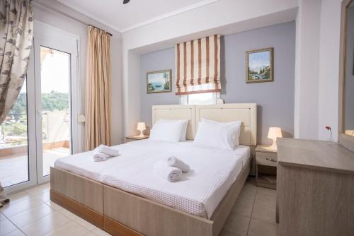 a bedroom with a bed with towels on it at Holiday Villa in Pefkochori