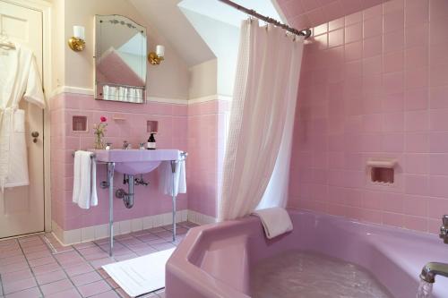 un bagno rosa con vasca e lavandino di The Inn at Tacaro Estate 