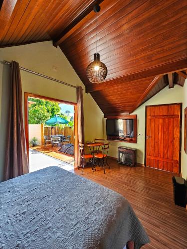 a bedroom with a bed and a table with chairs at Chalés Araucária e Manacá in São Bento do Sapucaí