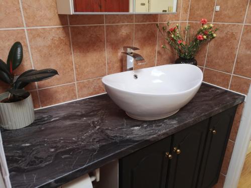 a bathroom with a white sink on a black counter at 2 bed flat, Bounds Green, Piccadilly line, London N11 in London