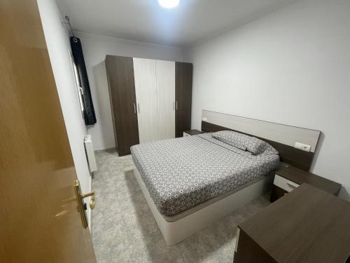 a small bedroom with a bed and a table at Apartamentos Atlas Terrassa V in Terrassa