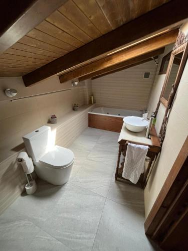 a bathroom with a toilet and a sink and a tub at Casa Rural Verde Oliva in Baños de la Encina