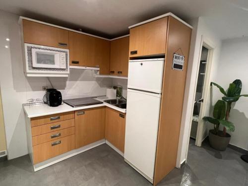 a small kitchen with a white refrigerator and a microwave at Apartmento en el corazon de Malasaña in Madrid