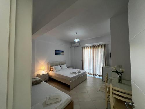 een slaapkamer met een bed, een tafel en een raam bij Garden Villa Eva in Sarandë