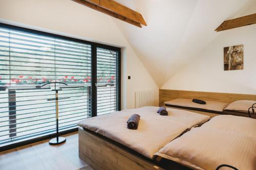 a bedroom with two beds and a large window at Vila Grín in Mýto pod Ďumbierom