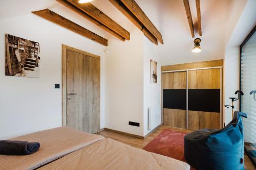 a bedroom with a bed and a wooden door at Vila Grín in Mýto pod Ďumbierom