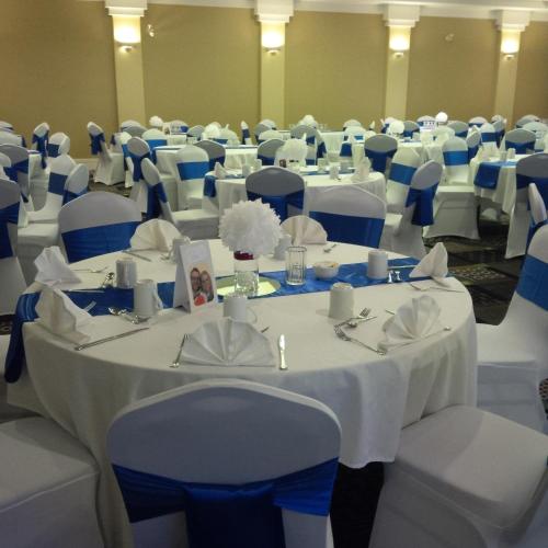 a room with white tables and chairs with blue chairs at Royal Hotel Regina, Trademark Collection by Wyndham in Regina