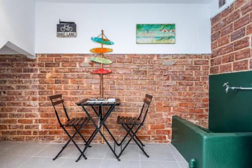 una mesa y dos sillas contra una pared de ladrillo en Beach House City, en Figueira da Foz