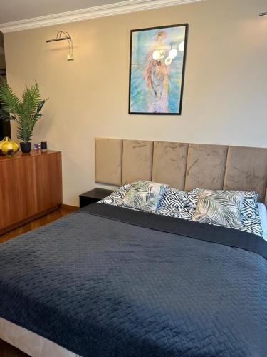 1 dormitorio con 1 cama con edredón azul en Venus Studio, en Zielona Góra