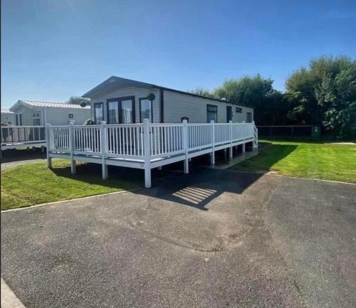 een grote witte stacaravan met een veranda bij The Luxe Lodge, Skipsea Sands Bridlington in Ulrome