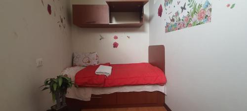 Habitación pequeña con cama roja en la esquina en Apartamento Acogedor, en Huancayo