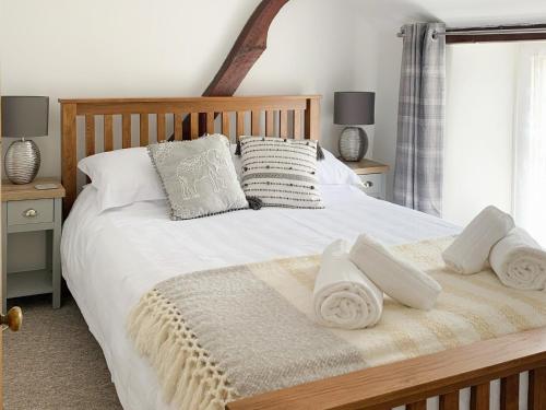 a bedroom with a bed with white sheets and pillows at Crossways in Uny Lelant